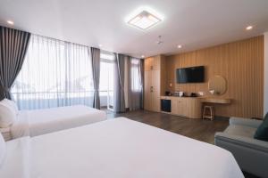 a hotel room with two beds and a television at HOANG LINH PHAT HOTEL in Da Lat
