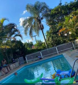 a swimming pool with chairs and a pool noodle at Chácara Recanto in Jarinu