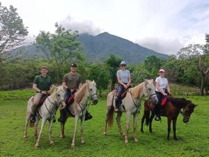 a group of people riding horses in a field at Finca Montaña Sagrada in Mérida