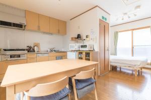 a kitchen with a large wooden table and chairs at Ken House Kyoto Shijo Omiya in Kyoto +21 photos
