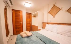a bedroom with a bed with two towels on it at Casa 12 do Paraíso - Atins in Atins