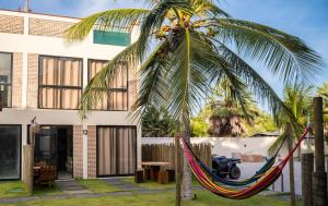 a hammock hanging from a palm tree in front of a building at Casa 12 do Paraíso - Atins in Atins