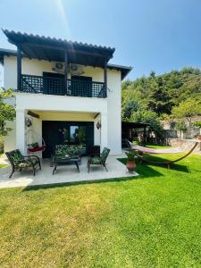 una casa con una hamaca frente a un patio en Detached Villa with Sea View, en Chaniotis 44 fotos más