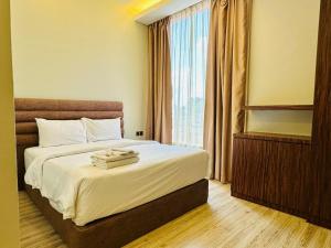 a hotel room with a bed and a window at Colors Hotel in Kulai +2 photos