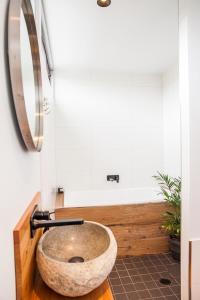 クレセント・ヘッドにある7 Pacific Street Terraces Crescent Headのバスルーム(石造りのシンク、バスタブ付)