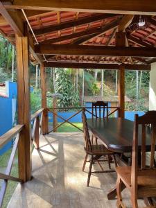 Una mesa y sillas de madera en un patio. en Casa de Campo Cantinho da Mata, en Domingos Martins
