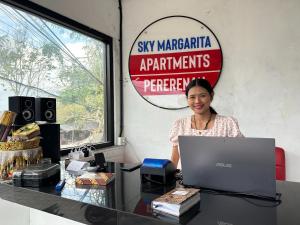 una mujer sentada en un escritorio con una computadora portátil en Sky Apartments and Suites, en Canggu 59 fotos más