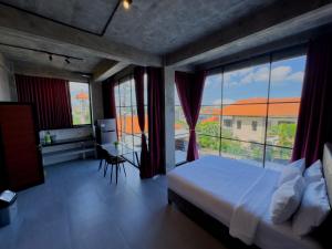Un dormitorio con una cama y una ventana grande. en Sky Apartments and Suites, en Canggu