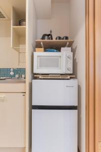 a microwave on top of a refrigerator in a kitchen at Ken Hotel Tokyo Shinjuku in Tokyo +37 photos