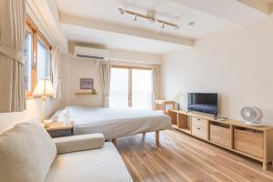 a hotel room with a bed and a tv at Ken Hotel Tokyo Shinjuku in Tokyo