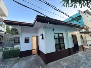 a white house with a black and white at Polos Place Homestay in Sorsogon