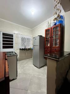 a large kitchen with a refrigerator and a window at Meu Encanto Itanhaém SP in Itanhaém +17 photos