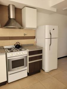 una cocina con estufa y refrigerador en Casa Rubí - Encantador apartamento en Mendoza - Cochera privada y seguridad permanente, en Guaymallén 12 fotos más