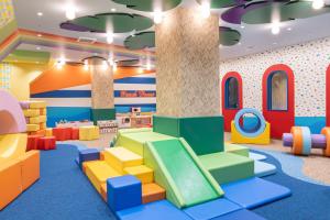 a childrens play room with colorful chairs and a slide at KAMENOI HOTEL Kujukuri in Asahi
