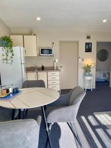 a kitchen with a table and chairs and a refrigerator at Heritage Park Lodge in Haast +44 photos