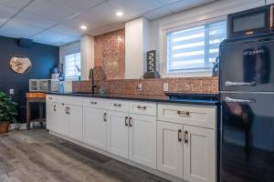 a kitchen with white cabinets and a black refrigerator at Magical Themed Decor! Pets Welcome! 3 Bedrooms in Chase