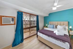 Un dormitorio con una cama con paredes azules y una ventana. en Family and Pet friendly Beachside, en Buddina