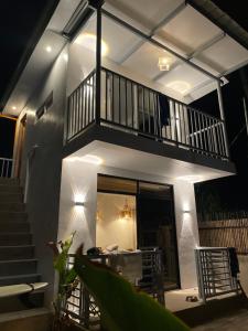a house with a balcony with a table and stairs at Padayon Island Stay in General Luna