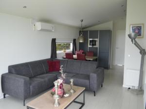 a living room with a couch and a table at Holiday home with gas fireplace & bath in Bemelen