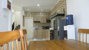 a kitchen with a wooden table and a refrigerator at Diyar Villas Puncak H1/6 in Puncak
