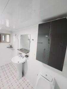 a white bathroom with a sink and a shower at Lucky House in Busan +6 photos