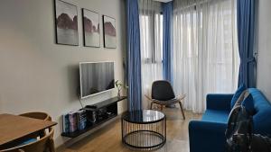 a living room with a blue couch and a tv at Home stay 2pn Hạ Long in Ha Long