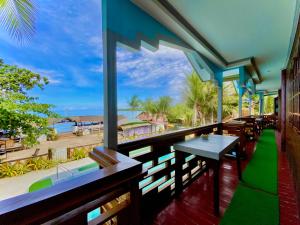 a balcony with a table and a view of the ocean at Jala Beach Resort in Loay