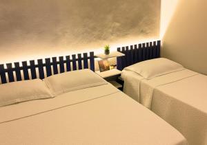 a bedroom with two beds and a table with a lamp at Apartamentos Porto Maravilha in Rio de Janeiro +70 photos