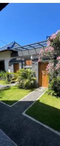 una casa con un jardín con flores y un camino de entrada en The Sun Bali Villa # 2, en Ngurah Rai International Airport