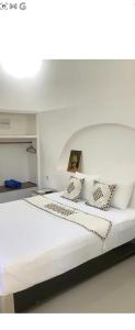 Una cama blanca con almohadas y un cuadro encima. en The Sun Bali Villa # 2, en Ngurah Rai International Airport 7 fotos más