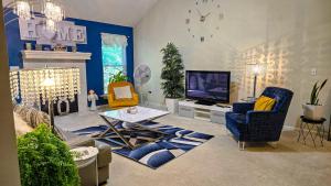 a living room with blue walls and a tv at Beautiful Townhome, 11 minutes to Downtown, KCMO. in Kansas City