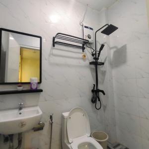 ein Badezimmer mit Waschbecken, Toilette und Spiegel in der Unterkunft Wyne's Tiny House near Royal Farm Resort in Dipolog City