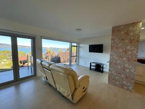 a living room with a couch and a large window at Rotorua Luxury lakeside Resort in Rotorua