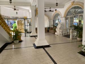 a lobby with columns and plants in a building at Le Hotel Hotel Phnom Penh in Phnom Penh