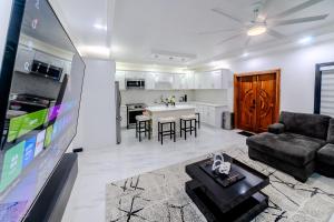 a living room with a tv and a couch and a table at Platinum22 - Across From AC Marriott Hotel in Kingston