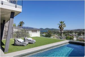 a swimming pool with two pillows on the grass next to a house at Beach, Golf & Luxury! Sunrise to Sunset Views in Forster