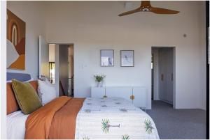 a bedroom with a bed and a ceiling fan at Beach, Golf & Luxury! Sunrise to Sunset Views in Forster +31 photos