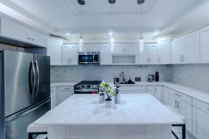 a kitchen with white cabinets and a white counter top at Platinum22 - Across From AC Marriott Hotel in Kingston