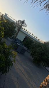 a white building with trees and bushes in front of it at Verdant gem in Bībīnagar