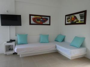 two beds in a room with blue pillows and a tv at Villa Nirvana - Villeta in Payandé
