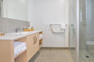 une salle de bain avec un lavabo et une douche dans l'établissement Robinvale Golf Club Resort, à Robinvale  2 autres photos