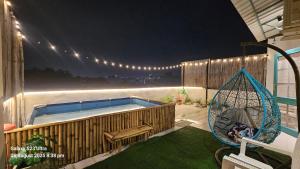 a backyard with a swimming pool and a swing at Mykonos Sky Penthouse Rooftop Pool 150" Cinema in Gurgaon