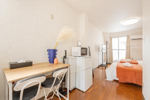 a room with a desk and a room with a bed at Shinjuku Wind Apartment • Cozy Retreats in Tokyo
