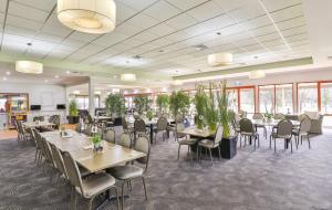 une salle à manger avec tables, chaises et fenêtres dans l'établissement Robinvale Golf Club Resort, à Robinvale 