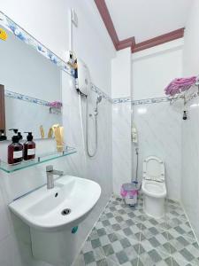 a white bathroom with a sink and a toilet at Gem's House 1- Balcony with Riverside View in Ho Chi Minh City
