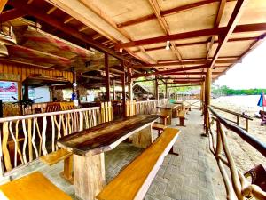 a wooden bench sitting inside of a restaurant at Jala Beach Resort in Villalimpia