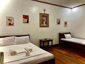 a bedroom with two beds and a cross on the wall at Jala Beach Resort in Villalimpia