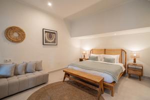 une chambre avec un lit et un canapé dans l'établissement Coral Heaven 2 by Bali Villa Solutions, à Seminyak
