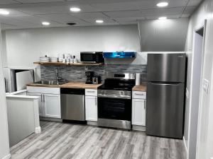a kitchen with stainless steel appliances and white cabinets at The Gorge Getaway 3BR 1BATH Close to Falls in Niagara in Niagara Falls