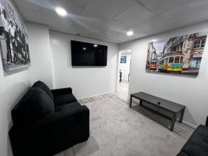 a living room with a couch and a tv on a wall at The Gorge Getaway 3BR 1BATH Close to Falls in Niagara in Niagara Falls